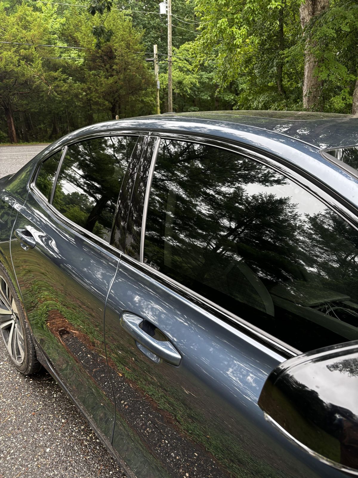 Close-up of ceramic-tinted window and pillar on a dark sedan