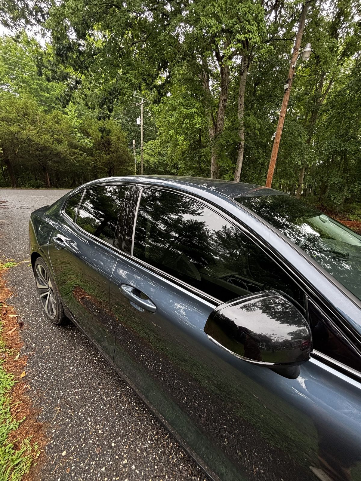 Close-up of ceramic-tinted rear window and pillar on a dark sedan